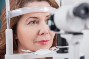 Pretty woman is looking into eye test machine