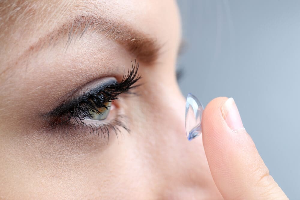 Girl putting contact lens in her eye