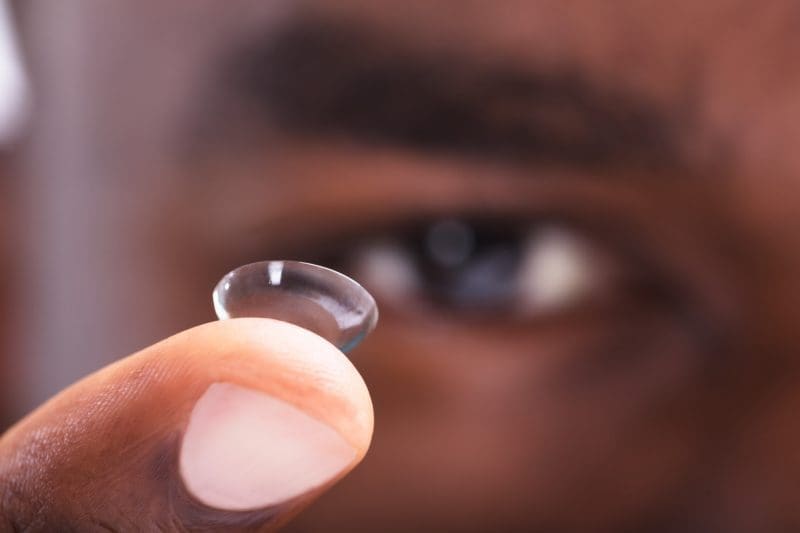 guy holding a contact lens