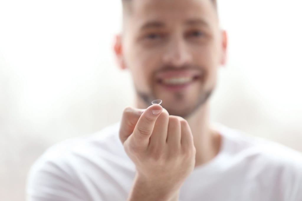 Man holding a contact lens,