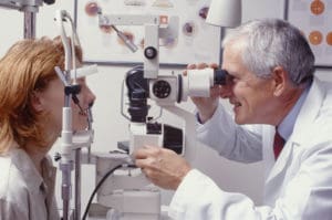 optometrist with patient, giving an eye examination