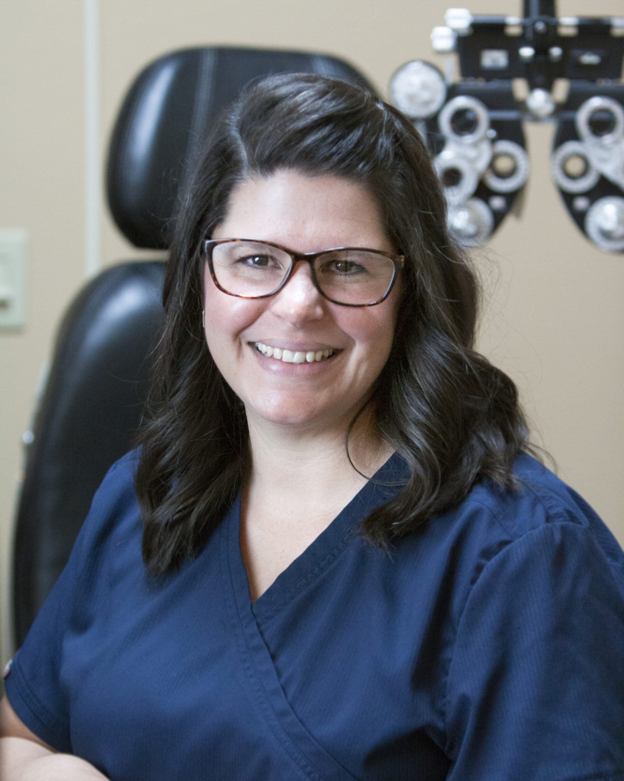 An optometrist in Idaho Falls smiling in front of an eye exam.