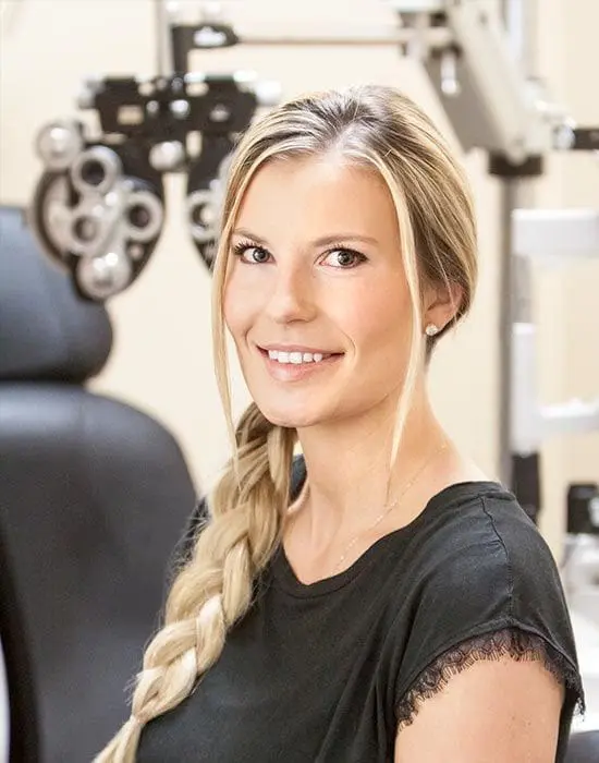 A smiling woman with a side braid and leadership qualities sitting in a gym.