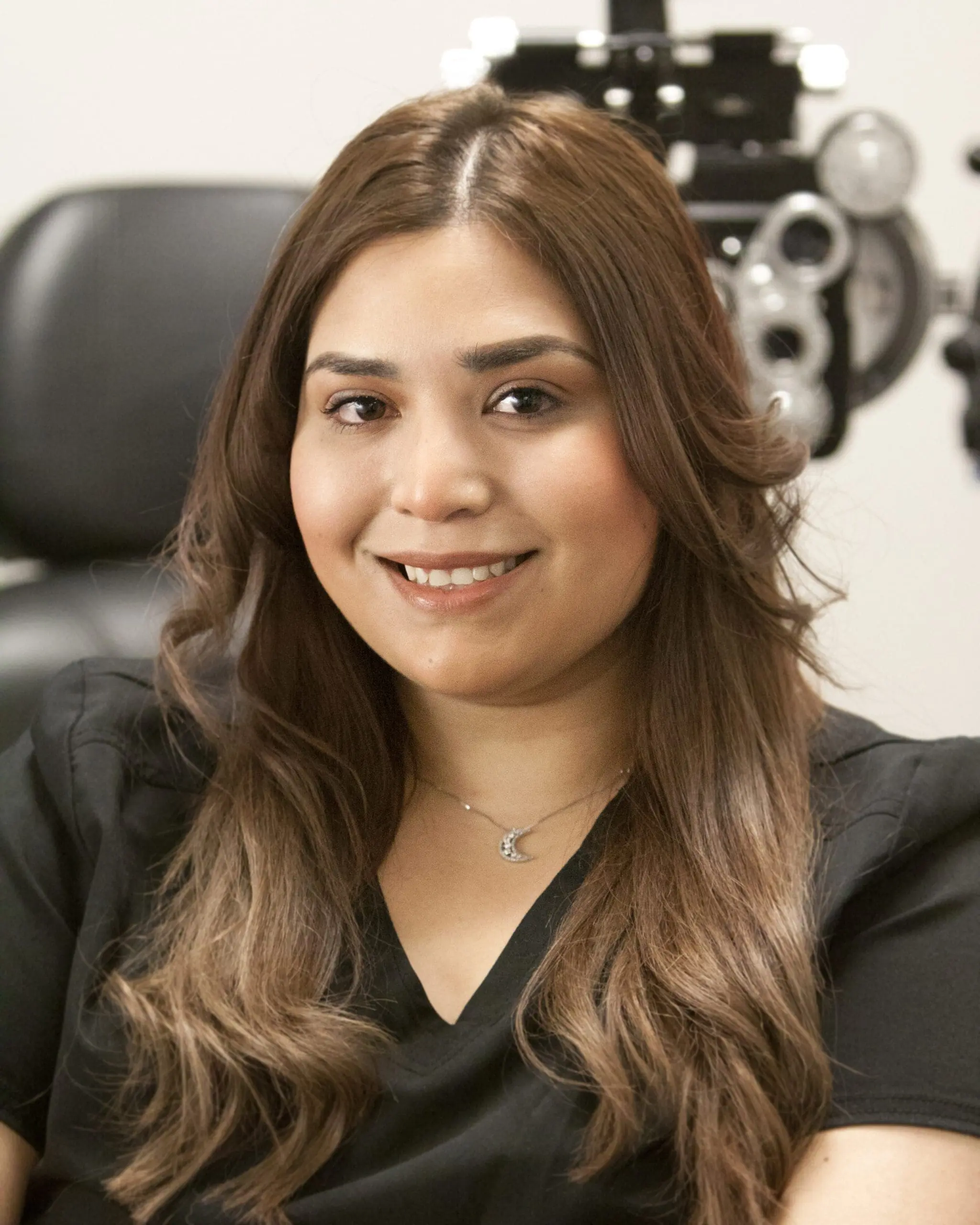 A woman smiling in front of an eye exam at the Optometrist Twin Falls.