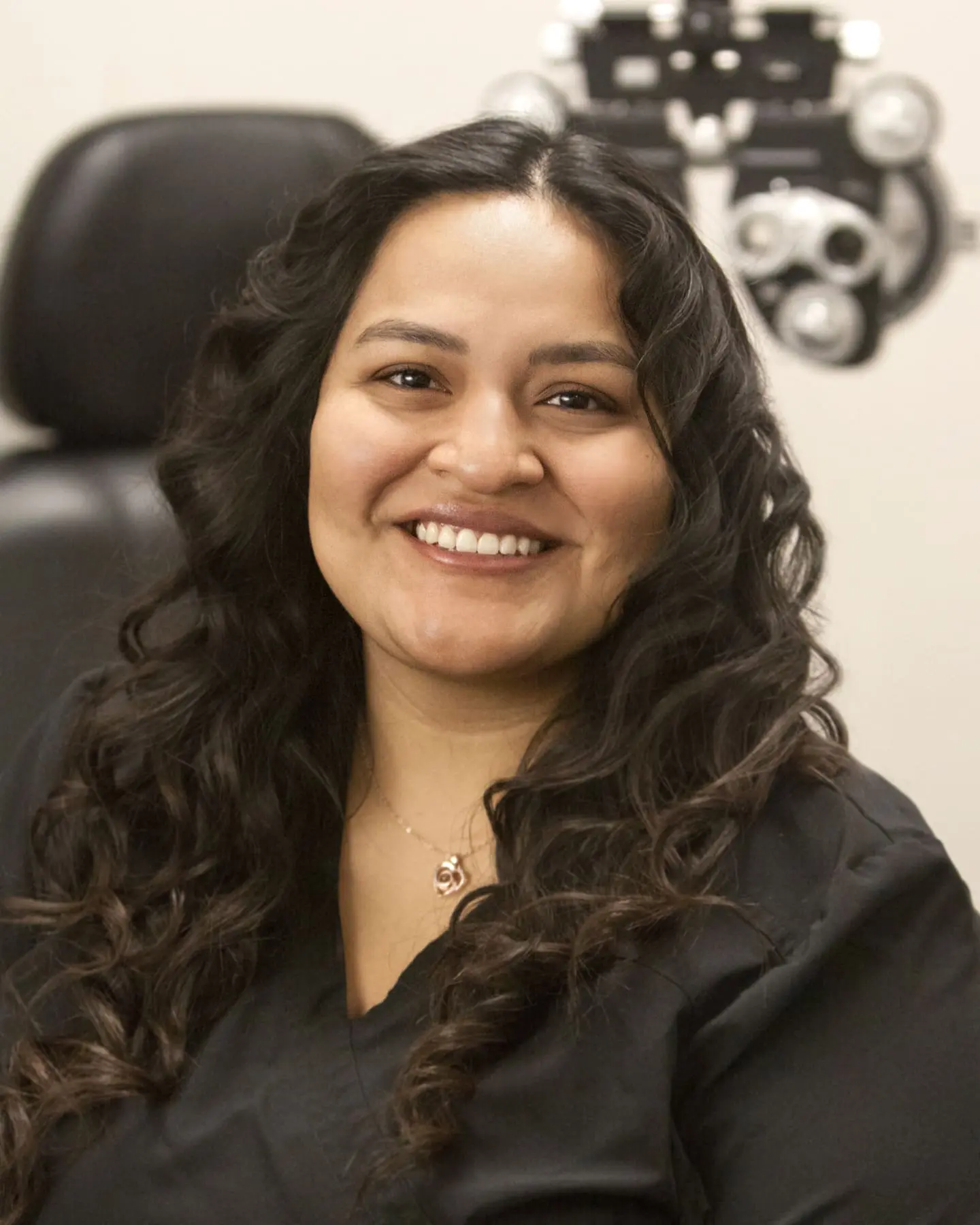 A woman smiling in front of an eyeglasses at the Eye Doctor Twin Falls.