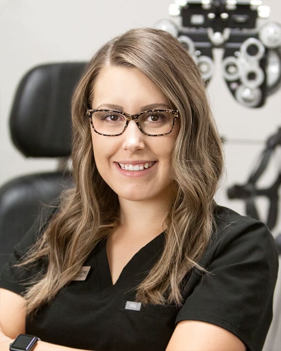 An optometrist in Nampa is standing in front of an eye exam machine.