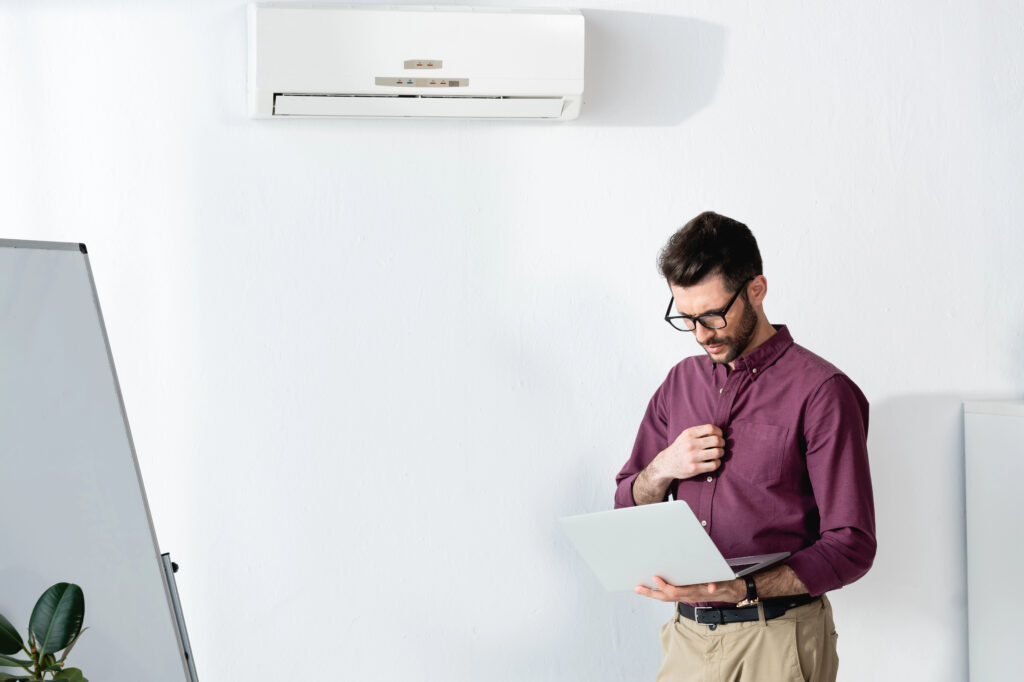 Man wearing glasses in an air-conditioned office, highlighting the importance of protecting eye health in dry, climate-controlled environments.