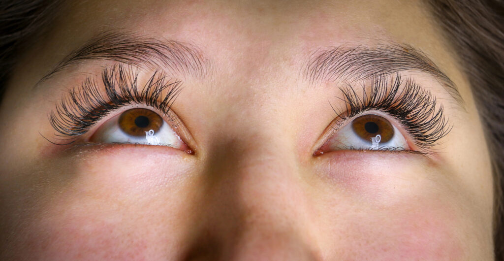 Close-up of a person's eyes looking upward, showcasing long eyelashes and neatly groomed eyebrows. This captivating gaze not only highlights natural beauty but also benefits from eye exercises to relieve strain and enhance focus.