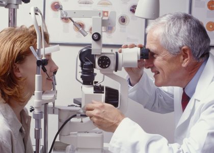 A doctor is conducting an eye exam on a woman.