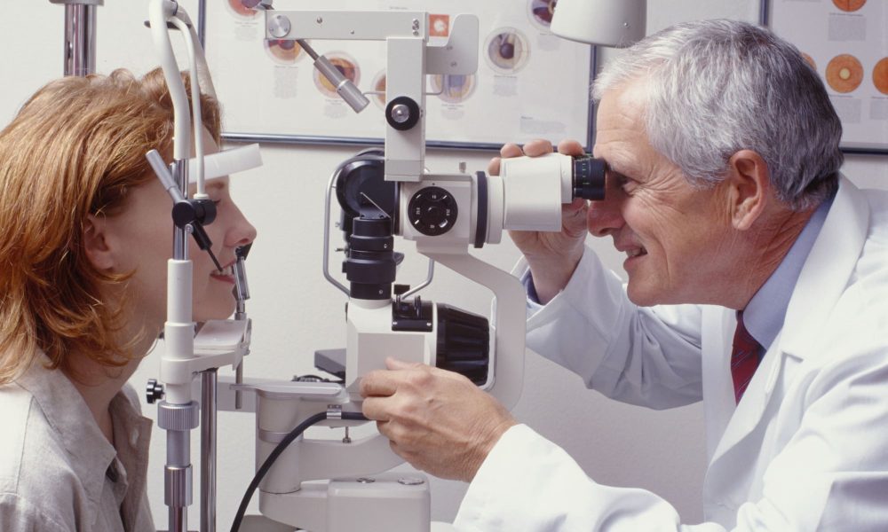 A doctor is conducting an eye exam on a woman.