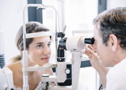 A woman is having her yearly eye exam conducted by an optometrist.