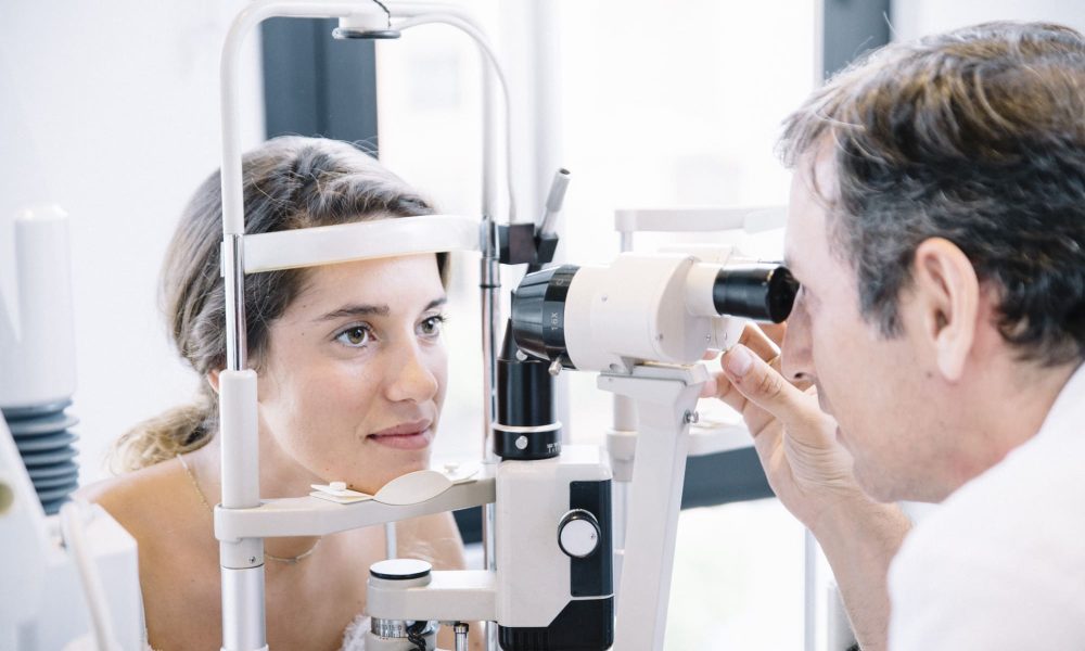 A woman is having her yearly eye exam conducted by an optometrist.