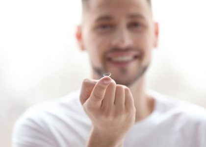 A man wearing contacts for the first time is holding a toothpick in his hand.