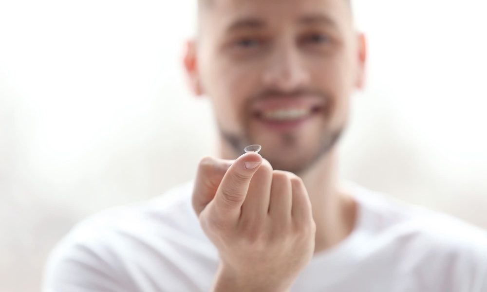 A man wearing contacts for the first time is holding a toothpick in his hand.