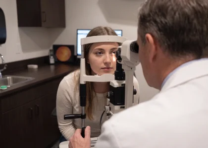 Optometrist performing a comprehensive contact lens exam on a female patient in Ogden, UT.