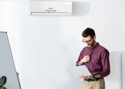 Man wearing glasses in an air-conditioned office, highlighting the importance of protecting eye health in dry, climate-controlled environments.