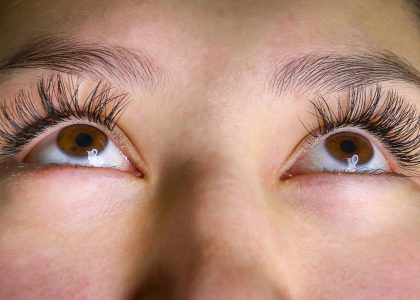 Close-up of a person's eyes looking upward, showcasing long eyelashes and neatly groomed eyebrows. This captivating gaze not only highlights natural beauty but also benefits from eye exercises to relieve strain and enhance focus.