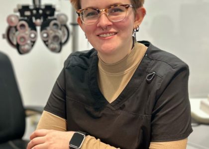 An Eye Pros optometrist smiling and posing in an examination room.