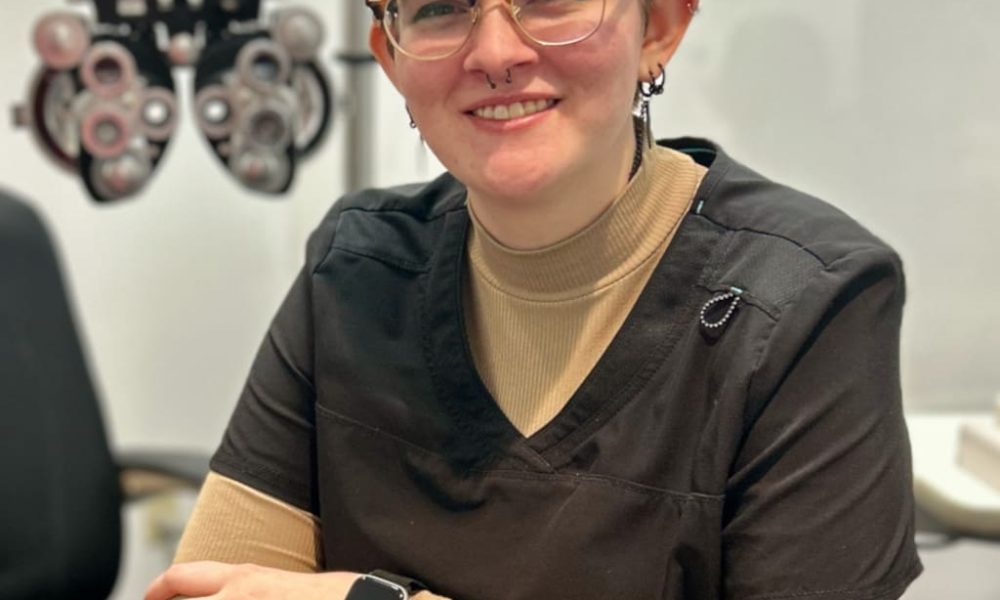 An Eye Pros optometrist smiling and posing in an examination room.