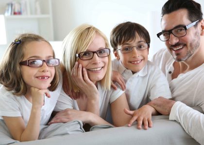 A family is posing for a picture at the best Eye Care Center in Idaho Falls while wearing glasses.