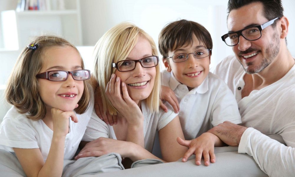 A family is posing for a picture at the best Eye Care Center in Idaho Falls while wearing glasses.