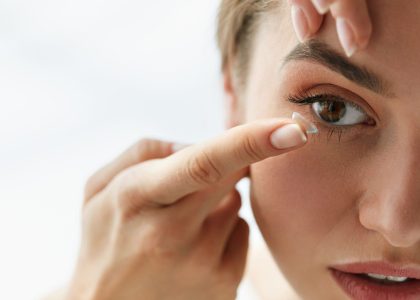 A woman is putting contact lenses with protein buildup on her eye.