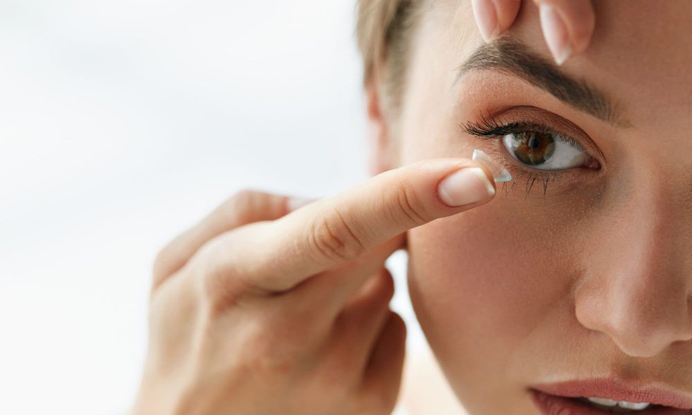 A woman is putting contact lenses with protein buildup on her eye.