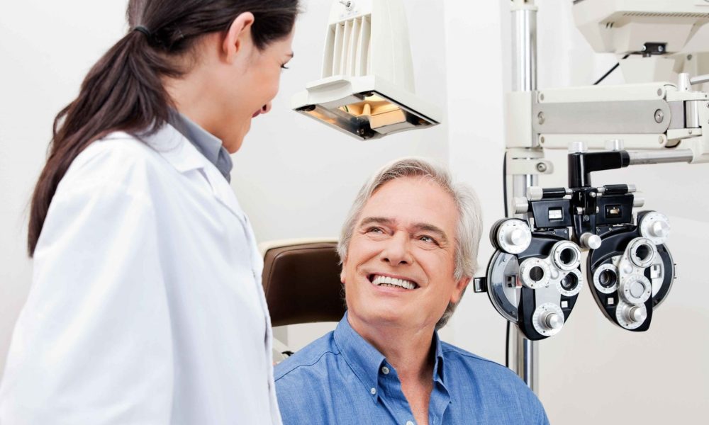 A man is smiling while sitting in front of a comprehensive eye exam machine in Nampa.