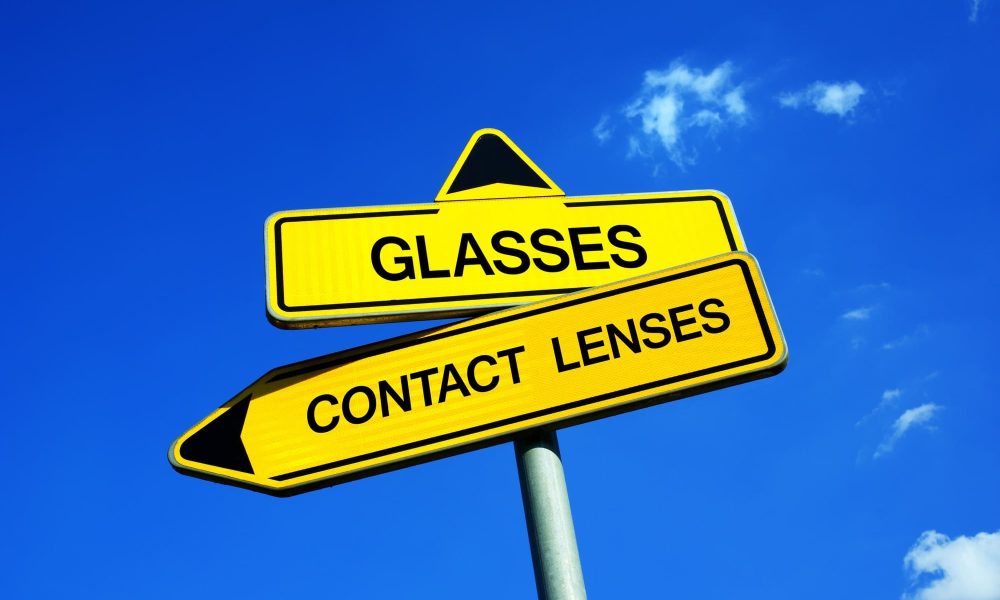 A yellow sign pointing to the options: contact lenses vs glasses.