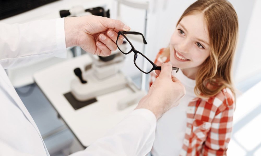 A young girl is getting her eyeglasses checked by the best optometrist.