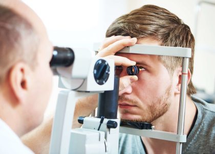 A man is having his eyes examined by an optometrist for glaucoma tests.