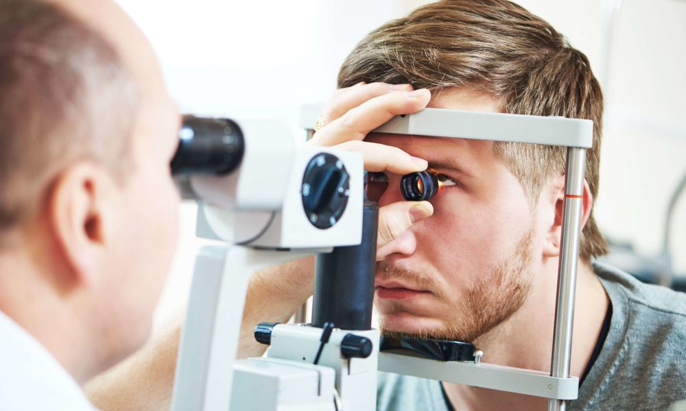 A man is having his eyes examined by an optometrist for glaucoma tests.