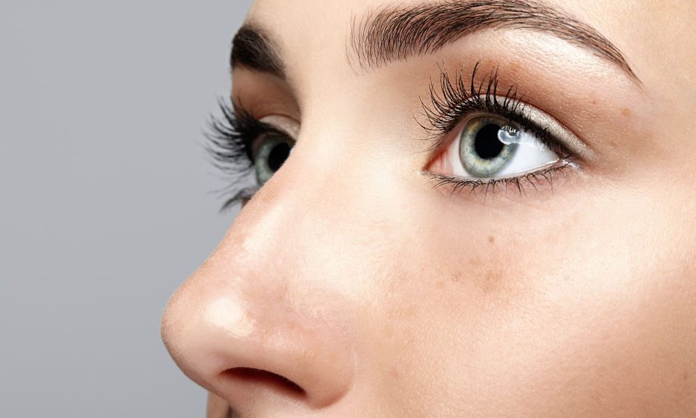 A close up of a woman's face highlighting eye vitamins.