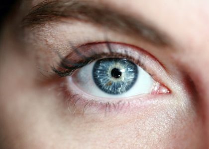 A close-up of a woman's blue eye, highlighting causes of blurred vision.