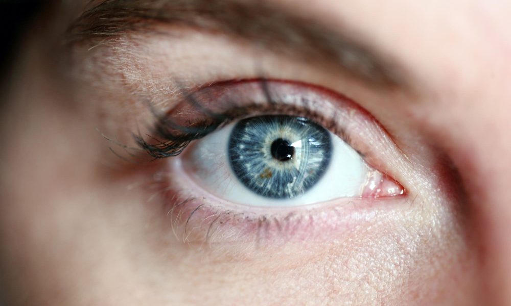 A close-up of a woman's blue eye, highlighting causes of blurred vision.