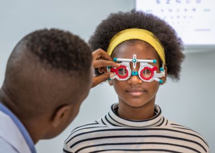 A young woman is being examined by an optometrist for the difference between nearsightedness and farsightedness.